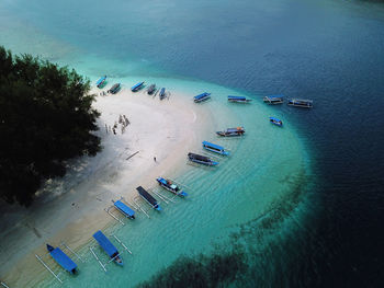 Aerial view of sailboats moored at island in sea