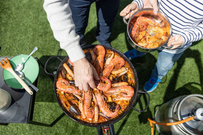 Grandfather and grandson preparing a paella in the garden