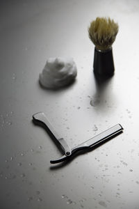 High angle view of shaving equipment on wet table