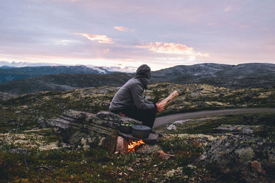 Man looking at mountain against sky