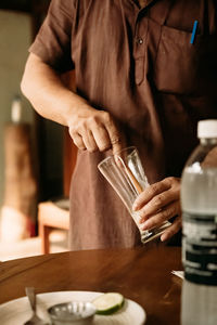 Midsection of woman drinking glass