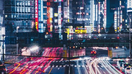 Digital composite image of illuminated city street and buildings at night