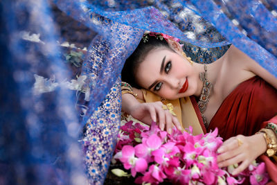 Portrait of bride with flowers under tulle netting