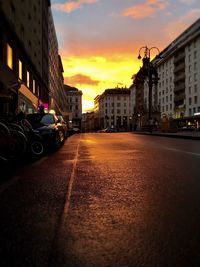 Cars on road against sky during sunset