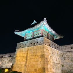 Low angle view of illuminated building against sky at night