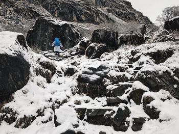Man standing on rock during winter