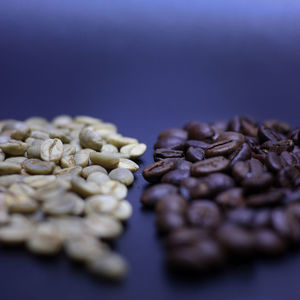 Close-up of coffee beans on table against black background