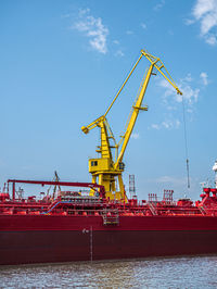 Cranes on pier against sky