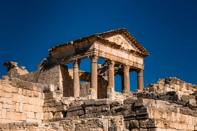 Low angle view of old temple against clear blue sky