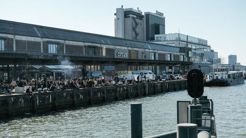 People in front of buildings against clear sky