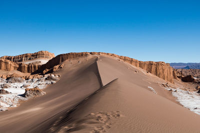 Scenic view of desert against blue sky