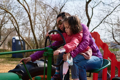 Mom and daughter pretending to ride a tractor at the county fair