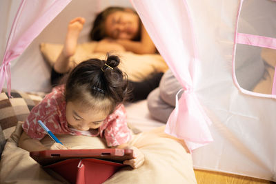 Rear view of woman lying on bed at home