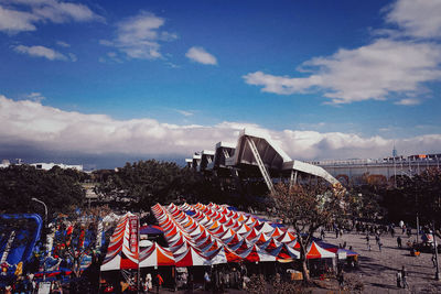 Group of people in city against blue sky