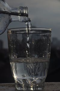 Close-up of glass pouring water on table