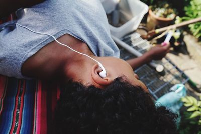 High angle view of boy listening music while relaxing outdoors