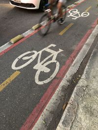 Low section of person riding bicycle on road