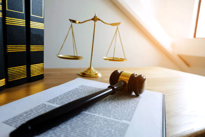 Close-up of book and hammer on table in court