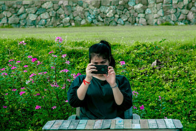 Full length of woman photographing at camera