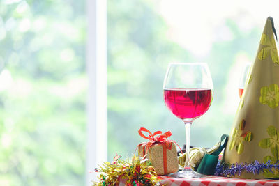 Close-up of red wine by decoration on table