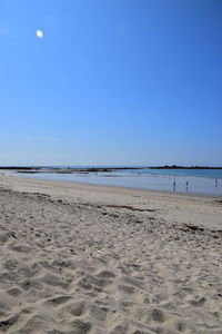 Scenic view of beach against clear blue sky