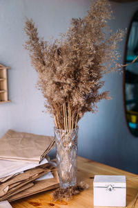 Dry reeds, reeds in vase, craft paper, wood and neutral colors in still life