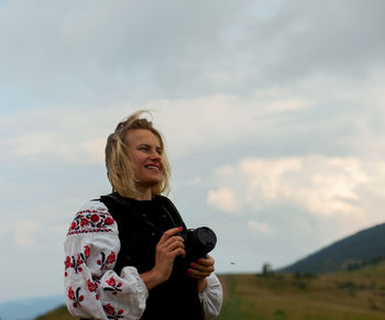 Girl photographer in the summer high in the mountains in the ukrainian embroidery