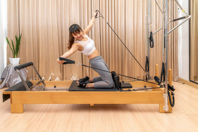 Side view of young woman sitting on floor