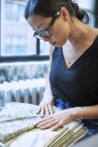 Interior designer looking at curtain samples while sitting in workshop