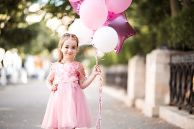 Portrait of young woman holding balloons