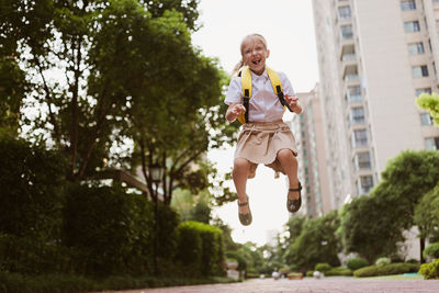 Full length of man jumping against trees