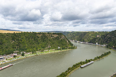 The river rhine in western germany flows between the hills covered with forest.