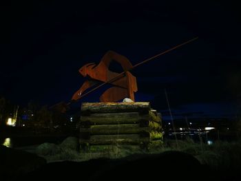 Illuminated traditional windmill against sky at night