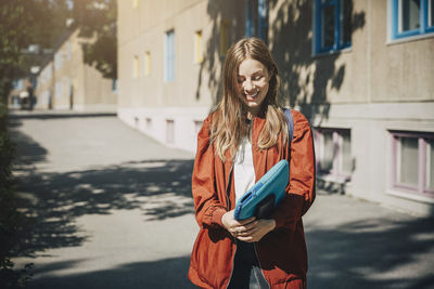 Young woman wearing mask standing on street in city