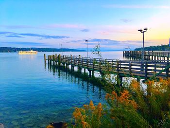 Pier on sea against sky during sunset