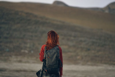 Rear view of woman standing against blurred background