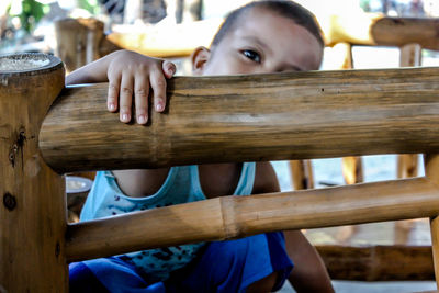 Close-up of boy on wooden bench
