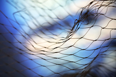 Close-up of metal fence against sky