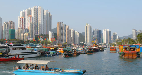 Boats in sea against buildings in city