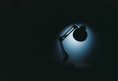 Low angle view of illuminated lamp in darkroom