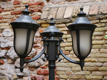 Low angle view of street light against brick wall