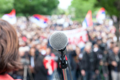 Rear view of woman microphone against audience