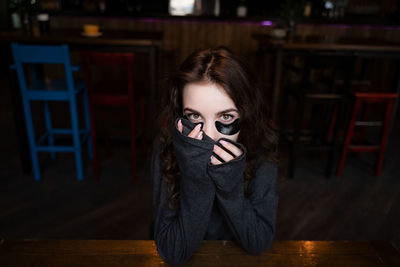 Portrait of beautiful young woman standing against wall