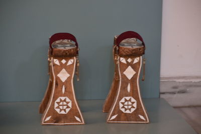 Close-up of shoes on table against wall