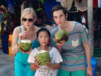 Portrait of family drinking coconut water in market