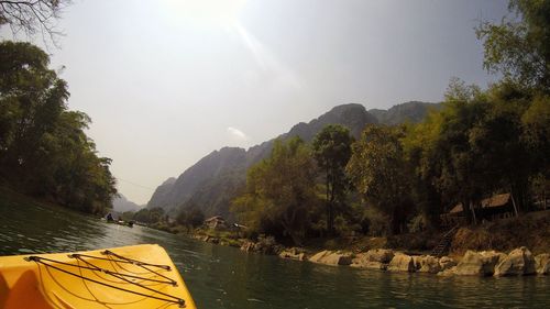 Scenic view of river by mountains against sky
