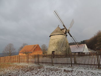 Traditional windmill on field against sky