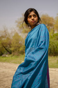 Beautiful woman wearing sari while standing against trees