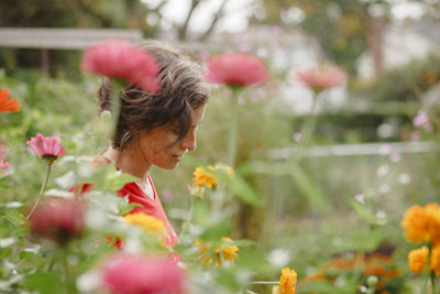 Rear view of woman with red flowering plants