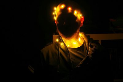Man sitting in illuminated lighting equipment